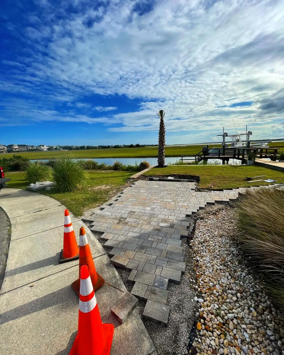 Salt-tolerant paver patio design for Carolina Beach NC coastal home with drainage and beach landscape