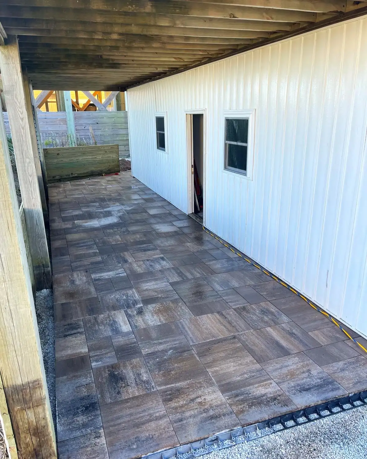Salt-tolerant paver patio design for Carolina Beach NC coastal home with drainage and beach landscape
