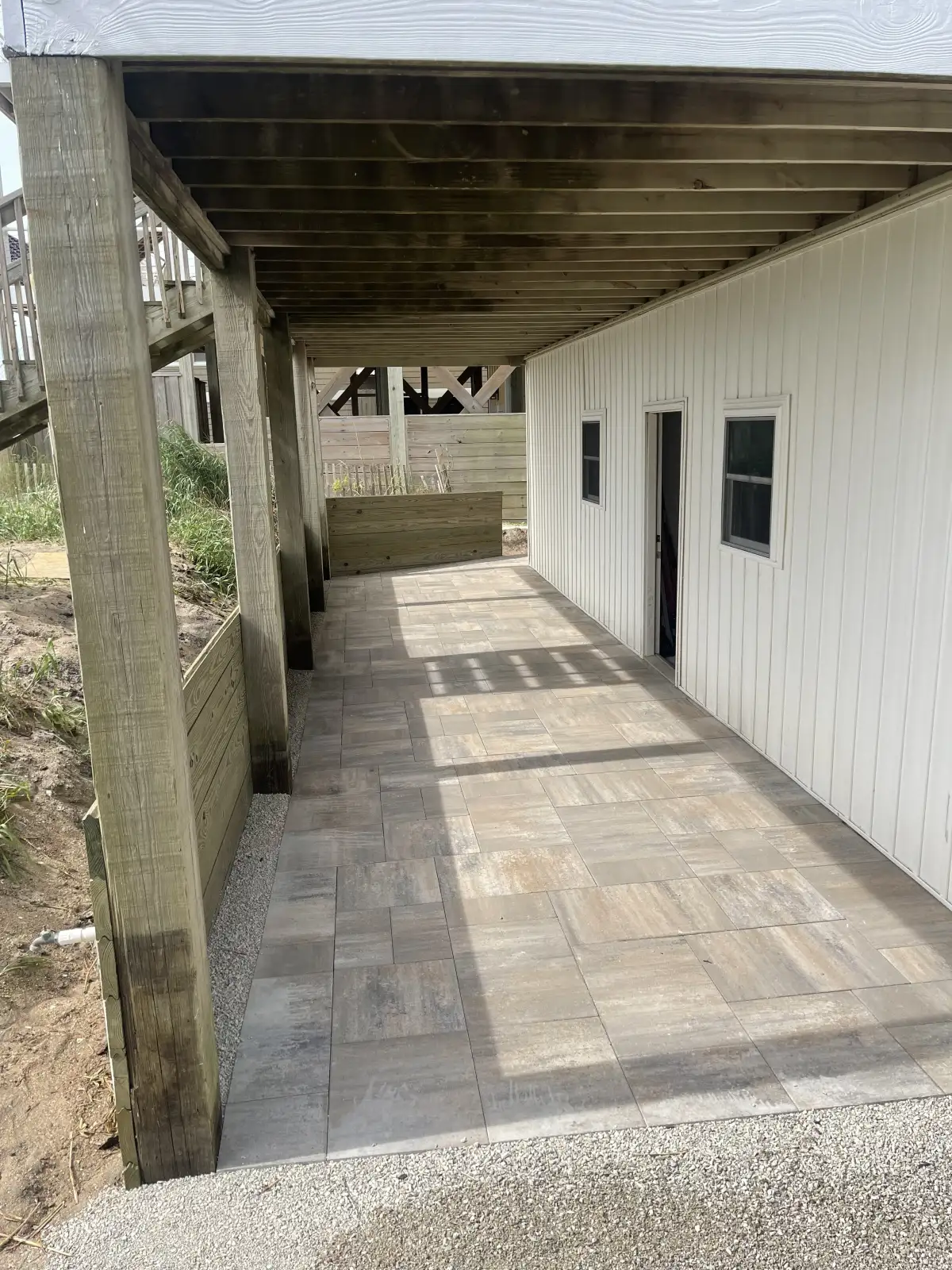 Luxury backyard fire pit area with Adirondack seating and stone walls in Wilmington NC