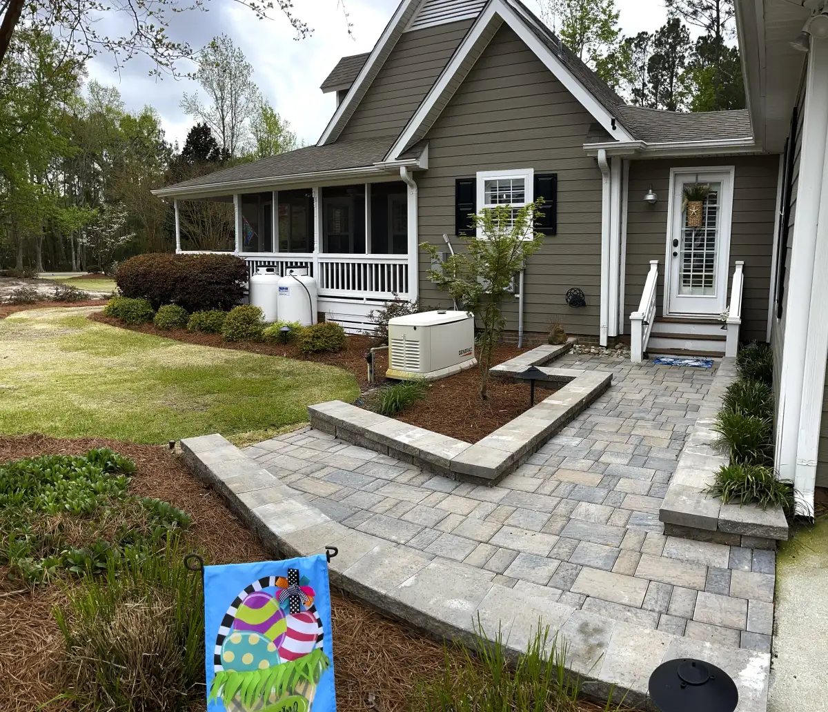 Luxury fire pit with built-in stone seating wall in coastal NC backyard